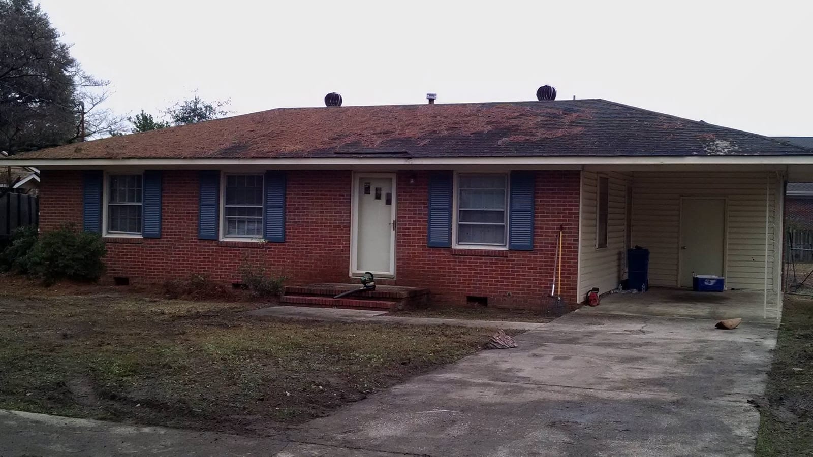 After: the same brick home with the pines removed and the yard cleaned up